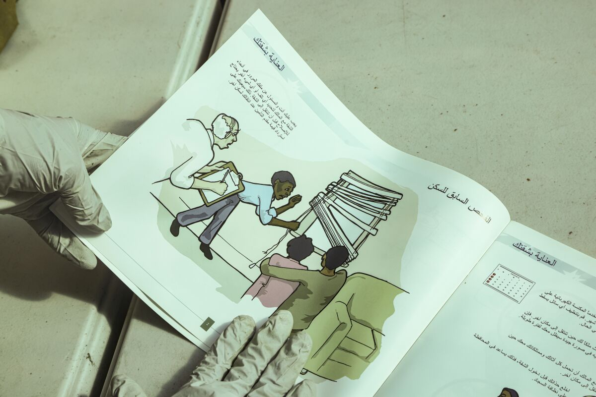 Un libro ilustrado con texto en árabe explica que jugar con las persianas de las ventanas es peligroso para los niños